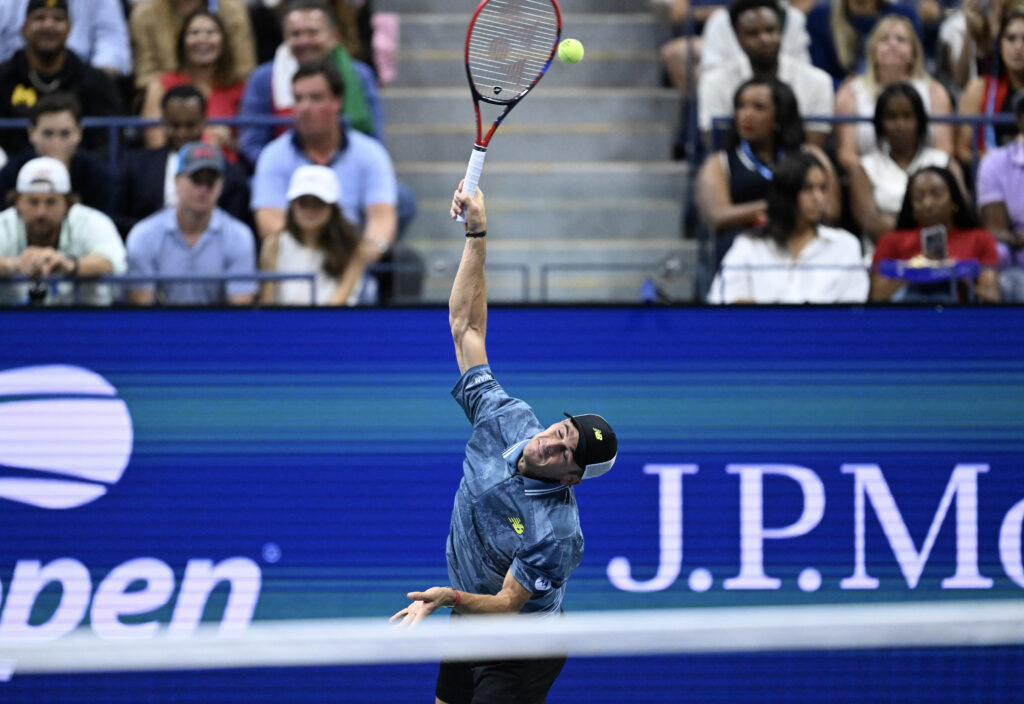 Tommy Paul serves at the US Open 2024 against Jannik Sinner